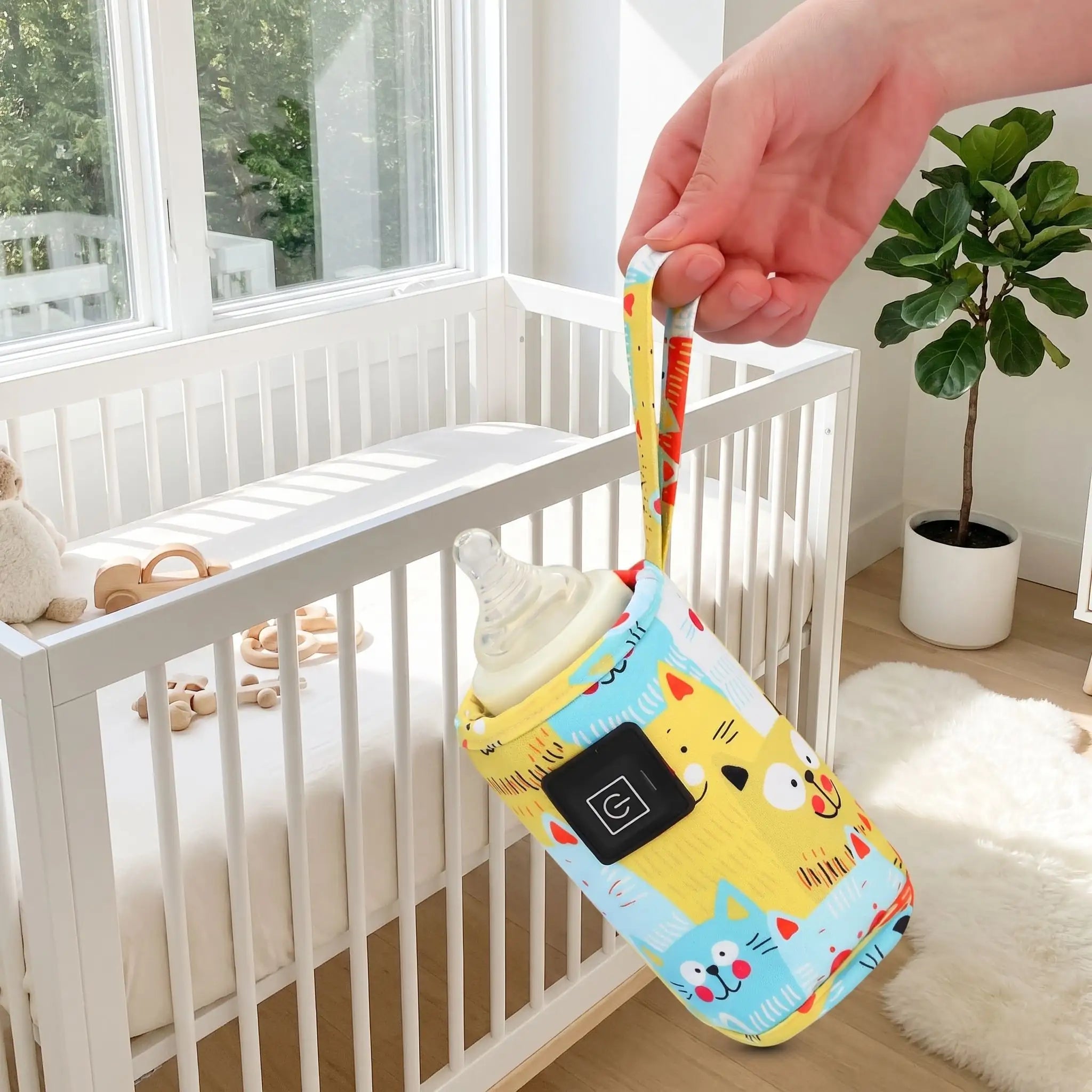 Chauffe biberon portable jaune porté par sa dragonne