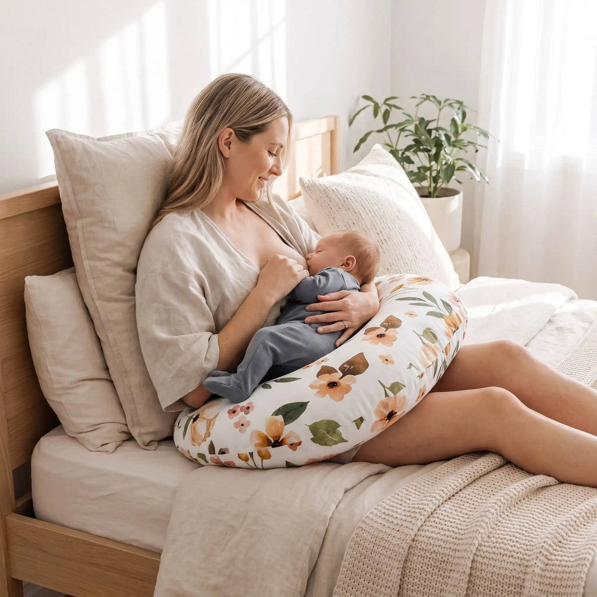 Maman qui allaite son bébé confortablement avec un coussin allaitement en forme de U floral