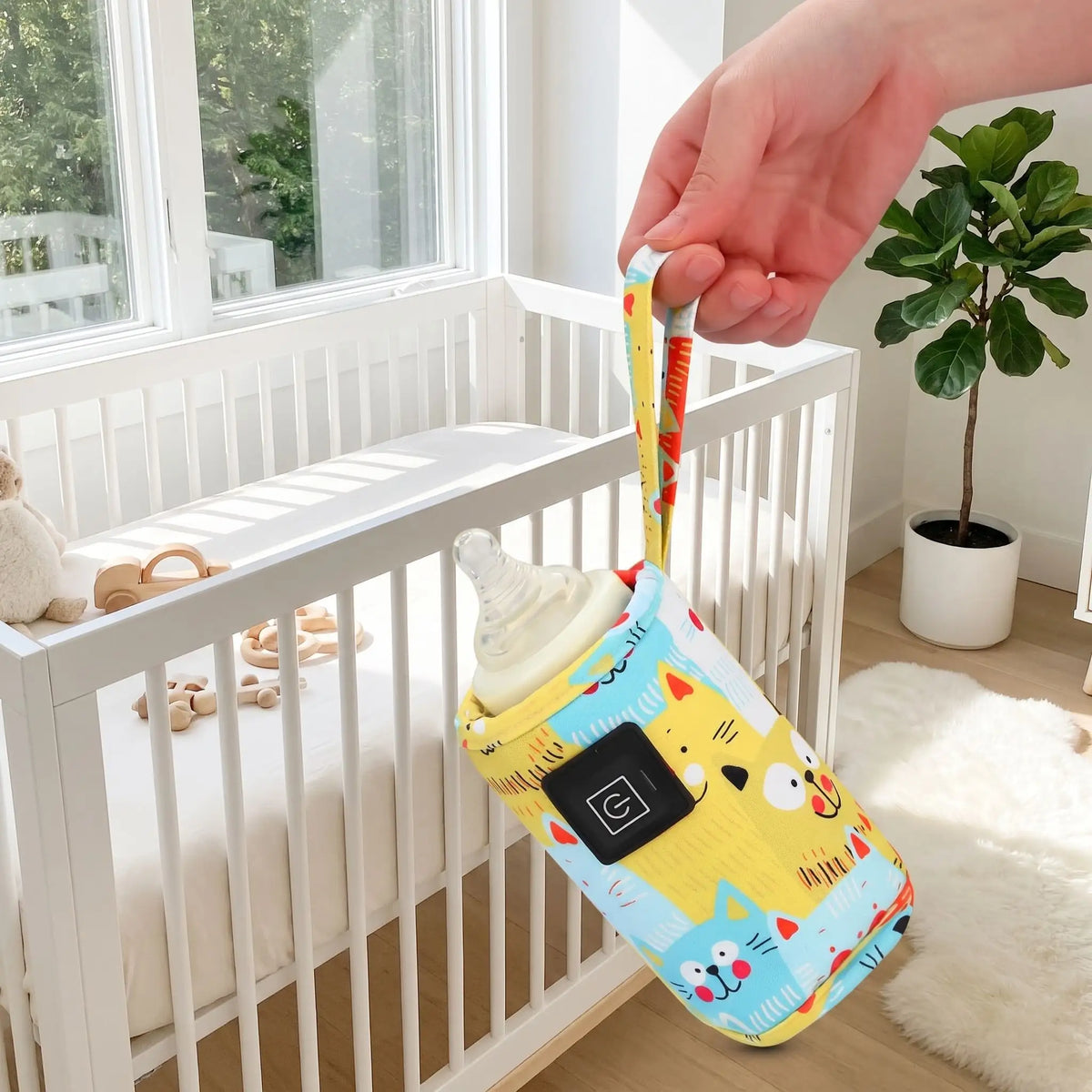 Chauffe biberon portable jaune porté par sa dragonne